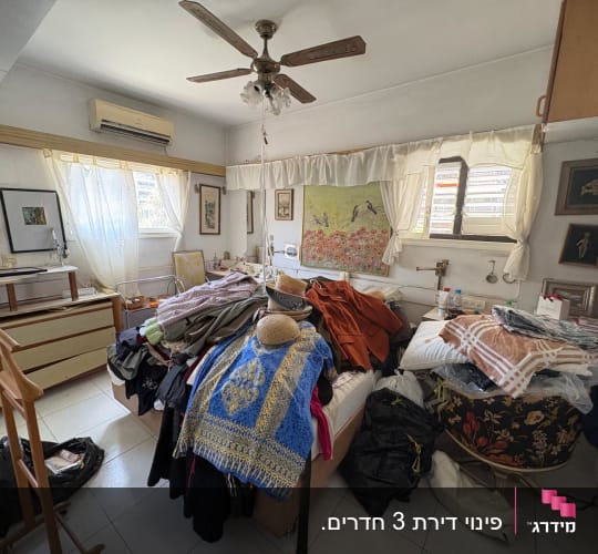 חדר עמוס בבגדים וחפצים, מתאים לפינוי בית